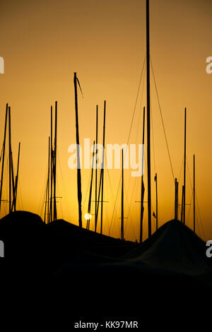 Hintergrundbeleuchtung der Boote im Sand bei Sonnenaufgang ruht. Stockfoto