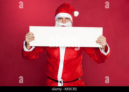 Die santa-klausel hält einen Platz für Werbung vor sich Stockfoto