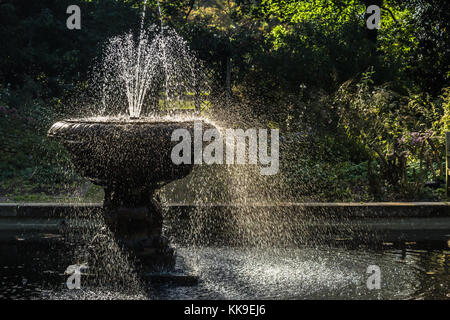 Schönen Brunnen mit Wasser spritzen im Wind, in einem wunderschönen englischen Garten gefunden. Stockfoto