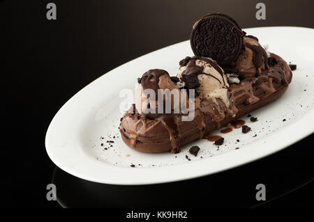 Waffeln und Eis in einem Gericht auf dunklem Hintergrund Stockfoto