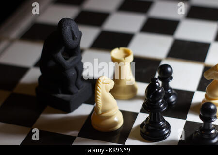 Der Denker Statue auf einem Schachbrett Spule kleine Denken über Strategie Lösung Stockfoto
