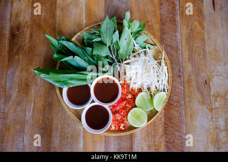 Traditionelle vietnamesische Küche. Frische Kräuter. Platten auf einem Holz- Oberfläche. Stockfoto