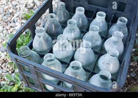 Kunststoff schwarz Kiste mit Zwanzig vier leere Glas Milch Flaschen. Stockfoto