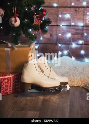 Frauen skates neben einem alten Leder Koffer und einen Weihnachtsbaum. Weihnachtsschmuck Stockfoto