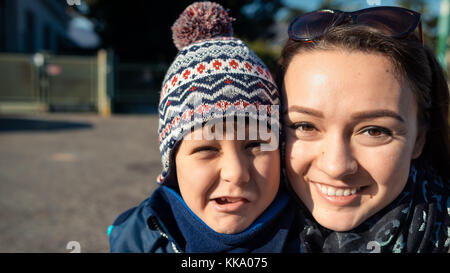 Junger Mann und eine junge Frau macht Gesichter und lächelnd in einem Park im Winter an einem sonnigen Tag Stockfoto