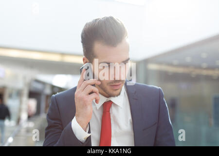Junge Unternehmer in formale Abnutzung der Aufruf in Financial Center in Innenräumen Stockfoto