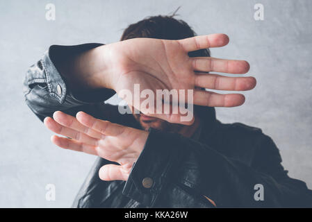Berühmtheit männlichen ausblenden Gesicht mit den Händen von paparazzi Fotografen, keine Fotos Geste Stockfoto