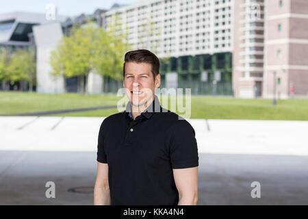 Gut aussehender Mann, der vor der Stadt im Freien Büros. Stockfoto