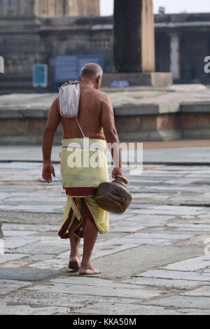 Morgen im Chenna Keshava Vishnu Tempel - Priester mit lota kalash Topf Opfergaben - Priester mit Kuferkrug beim Wasser holen Stockfoto