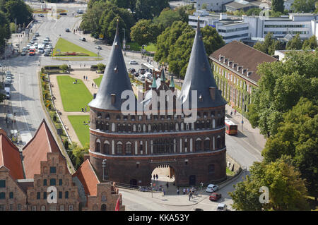 Luftaufnahme des Holstentors, eines Stadttors und alter Lagerhäuser in Lübeck Stockfoto