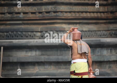 Morgen im Chenna Keshava Vishnu Tempel - Priester mit lota kalash Topf Opfergaben - Priester mit Kuferkrug beim Wasser holen Stockfoto