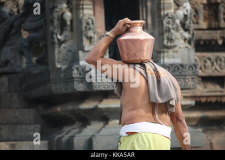 Morgen im Chenna Keshava Vishnu Tempel - Priester mit lota kalash Topf Opfergaben - Priester mit Kuferkrug beim Wasser holen Stockfoto