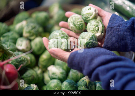 Frau mit lokal angebauten biologischen rosenkohl an einem Gemüsestand eines Bauernmarktkiosks in BC, Kanada. Stockfoto