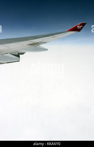 Steuerbord Flügel einer Boeing 747 Virgin Atlantic Flying über weiße Wolke in großer Höhe Stockfoto