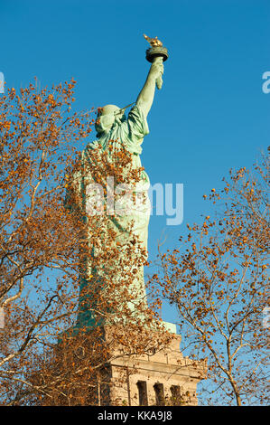 Freiheitsstatue Ansicht von hinten gegen den blauen Himmel hinter Bäumen in aut Stockfoto