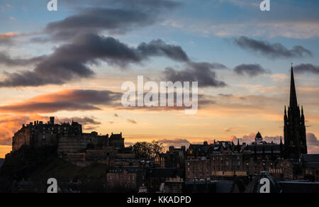 Edinburgh, Schottland, Vereinigtes Königreich. 29 Nov, 2017. Dramatischer Sonnenuntergang über Edinburgh Skyline auf dem Dach in Richtung Edinburgh Castle Felsvorsprung mit den Silhouetten der Nabe spire und Royal Mile Dächer suchen Stockfoto