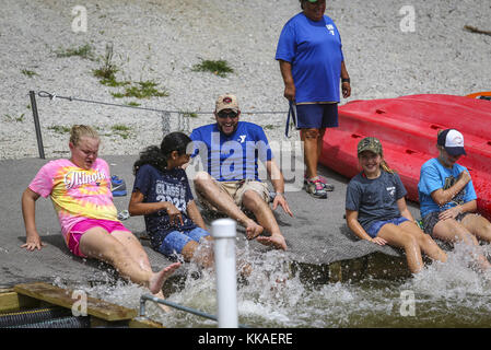 Illinois City, Iowa, USA. August 2017. YMCA Camper Haley Hotchkiss, 12, links, Julianne Binto, 11, Kylee White, 12, und Lilly Elliot, 12, versuchen, Wasser auf Rock Island Programm-Koordinator Rich Yerington während ihrer Mittagspause am Lake George in Illinois City, Illinois, am Donnerstag, 17. August 2017 zu treten und zu spritzen. Kredit: Andy Abeyta, Quad-City Times/Quad-City Times/ZUMA Wire/Alamy Live News Stockfoto