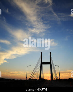 Burlington, Iowa, USA. August 2017. Die Sonnenuntergänge auf der Great River Bridge zwischen Gulf Port, Illinois und Burlington, Iowa 9. August 2017. Der Bau der Struktur begann 1989, aber die Arbeiten am Hauptturm begannen erst im April 1990. Der Hauptturm ist 370 Meter hoch von der Spitze des Turms bis zum Flussbett. Während der Großen Flut von 1993 wurde der Bau trotz Rekordhochs auf dem Mississippi fortgesetzt. Die endgültigen Kosten für die Brücke betfen 49 Millionen Dollar, etwa 16 Prozent über dem Budget. Die Brücke ersetzt die MacArthur Bridge, eine alternde zweispurige, freitragende, Stahl-Mautbrücke Stockfoto