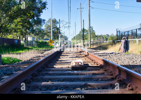 Bahngleise verschwinden in den Abstand in den frühen Morgen. Stockfoto