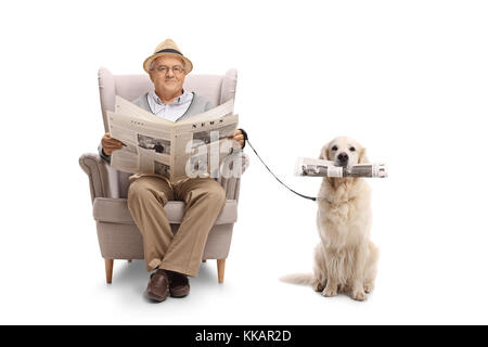 Reifer Mann im Sessel halten eine Zeitung und ein Labrador Retriever mit einer Zeitung auf weißem Hintergrund sitzt Stockfoto