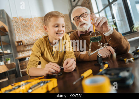 Freuen positive Großvater mit einem Schraubendreher Stockfoto