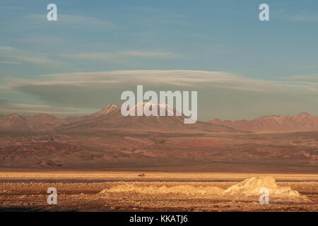 Wanderer auf der Atacama Salt Flats, mit schneebedeckten Vulkangipfel im Hintergrund, in der Nähe von San Pedro de Atacama, Chile, Südamerika Stockfoto