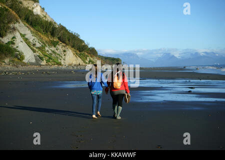 Mutter mit Tochter zu Fuß am Strand bei Ebbe, die Kachemak Bucht, Homer, Alaska Stockfoto