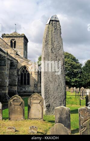 Rudston monolith, späte Jungsteinzeit 26 ft. Standing Stone neben rudtson Pfarrkirche Allerheiligen, East Yorkshire, England, Großbritannien Stockfoto