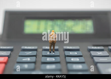 Miniatur Geschäftsmann auf der Grau-Rechner Stockfoto
