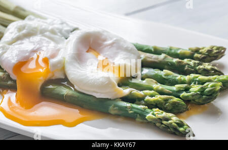 Gedünsteter Spargel mit pochiertem Ei auf der Platte Stockfoto