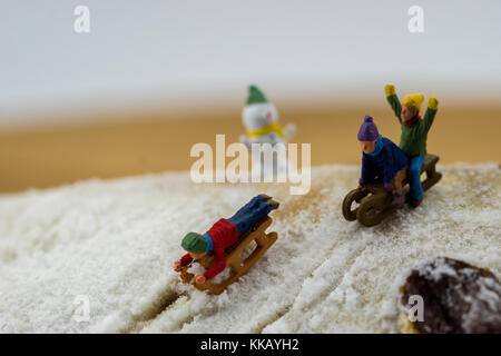 Winter Konzept Kinder rutschen schneebedeckten Berg Kuchen Stockfoto