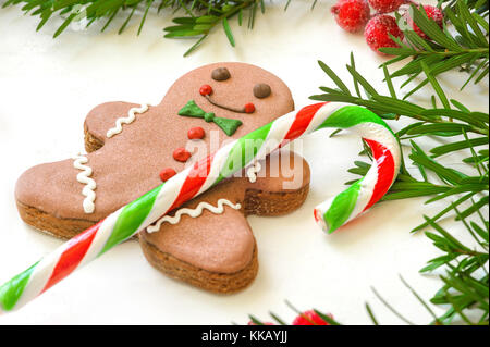 Weihnachten Hintergrund. Lebkuchen Männer und Weihnachten Stock auf einem weißen Holz- Hintergrund Stockfoto