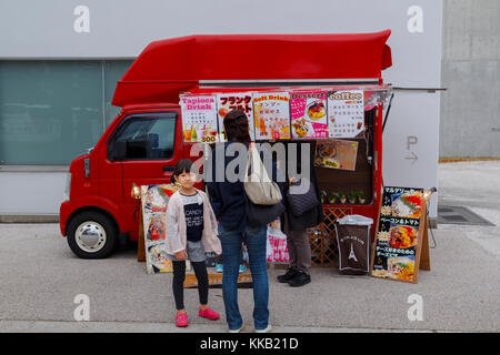 Japanische Mädchen mit ihrer Mutter in einer Essen Lkw rot van während eines Festivals in Kanazawa, Japan Stockfoto