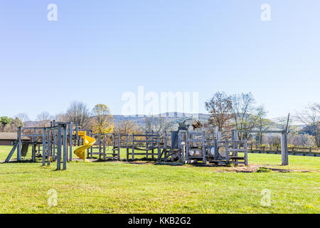 Der Holz- Kinderspielplatz leer in der Landschaft, die von der Schule mit Rutsche in den Bergen, auf dem Land, in den ländlichen Stockfoto