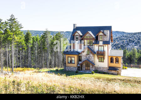 Schweizer bayerischen Stil Alpine Haus in den Bergen mit großen Mehrstöckigen Glasfenster im Herbst oder Winter, Pinienwald Stockfoto