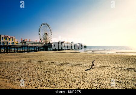Paar am Strand von Blackpool mit Pier Riesenrad Kirmes. Liebhaber, sandigen Strand entlang spazieren. Lancashire, England. Sommerabend. Stockfoto