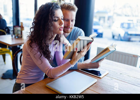 Junges Paar Bücher lesen Im Café Stockfoto
