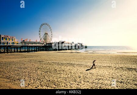 Paar am Strand von Blackpool mit Pier Riesenrad Kirmes. Liebhaber, sandigen Strand entlang spazieren. Lancashire, England. Sommerabend. Stockfoto