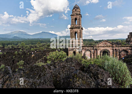 Der Turm der Kirche San Juan Parangaricutiro ragt aus einem Meer aus getrocknetem Lavagestein im abgelegenen Dorf San Juan Parangaricutiro, Michoacan, Mexiko, hervor. Diese Kirche ist die einzige noch verbliebene Struktur, die beim achtjährigen Ausbruch des Vulkans Paricutin begraben wurde, der 1943 zwei Dörfer verzehrte und die Region mit Lava und Asche bedeckte. Stockfoto