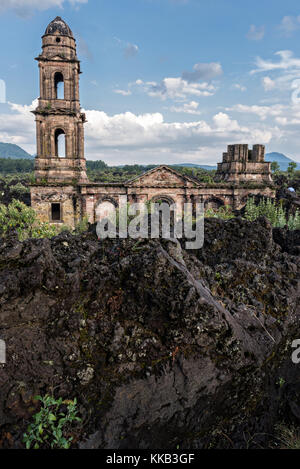 Der Turm der Kirche San Juan Parangaricutiro ragt aus einem Meer aus getrocknetem Lavagestein im abgelegenen Dorf San Juan Parangaricutiro, Michoacan, Mexiko, hervor. Diese Kirche ist die einzige noch verbliebene Struktur, die beim achtjährigen Ausbruch des Vulkans Paricutin begraben wurde, der 1943 zwei Dörfer verzehrte und die Region mit Lava und Asche bedeckte. Stockfoto