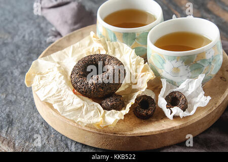 Porzellan chinesische Schalen, Stahl Teelöffel. Schwarz, Grün, Puerh, Oolong, tieguanyin, Sencha, Tee. grauer Hintergrund Stockfoto