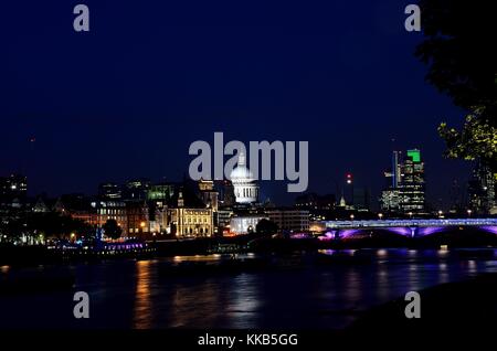 Die St Paul's Kathedrale, nachts genommen über die Millennium Bridge über die Themse fotografierte, Hingabe, in der einige nette Reflexionen. Stockfoto