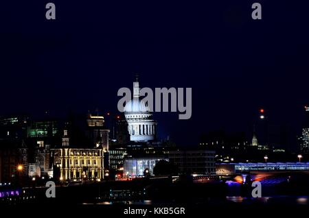 Die St Paul's Kathedrale, nachts genommen über die Millennium Bridge über die Themse fotografierte, Hingabe, in der einige nette Reflexionen. Stockfoto