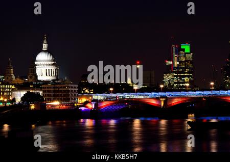 Die St Paul's Kathedrale, nachts genommen über die Millennium Bridge über die Themse fotografierte, Hingabe, in der einige nette Reflexionen. Stockfoto