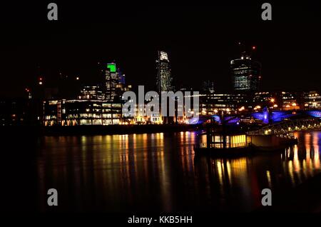 Die St Paul's Kathedrale, nachts genommen über die Millennium Bridge über die Themse fotografierte, Hingabe, in der einige nette Reflexionen. Stockfoto