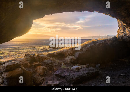 Island Höhleneingang, Blick auf das Meer im warmen Sonnenlicht zu niedrig Stockfoto