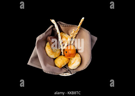 Verschiedene Brot im Korbe. top anzeigen. auf einem schwarzen Hintergrund isoliert Stockfoto