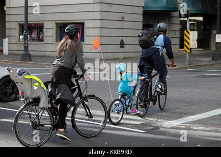 Eine junge Familie mit Kleinkind und Baby Fahrrad in einer Straße der Innenstadt in den USA Westküste Stadt Portland, Oregon, USA KATHY DEWITT Stockfoto