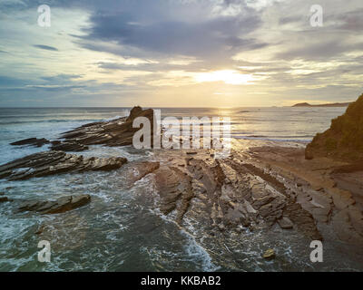 Surfer in magnific Rock bay Nicaragua. Sonnenuntergang im Meer Küste Stockfoto