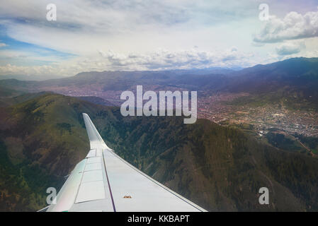 Flugzeugflügel unter der Stadt in den Bergen mit Stadt Cusco Peru Stockfoto